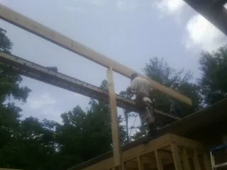 Carpenter setting a ridge beam over a new addition frame — Ice Dam Removal by Roofing Brothers in Anadarko