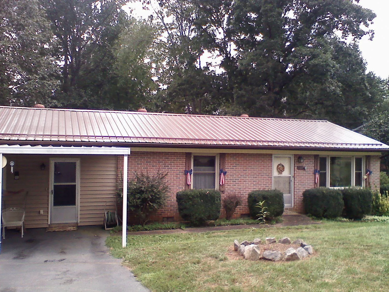 Bronze metal roof and carport on a brick ranch home — Roof Repair work by our crew in Anadarko