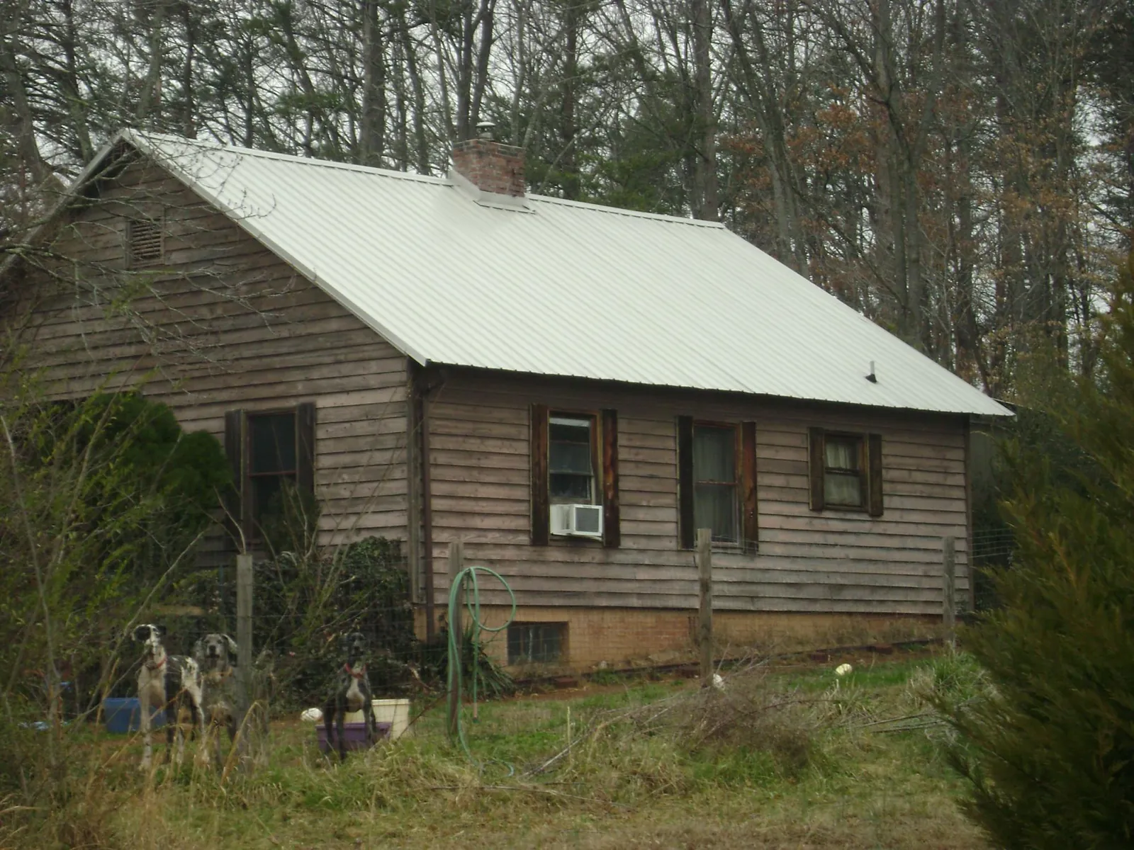 White metal roof on an old wood sided farmhouse, from a Metal Roof Installation job in Anadarko